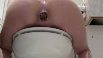 Girl pooping close-up while seated on the toilet