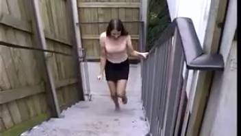 Young woman peeing on the staircase